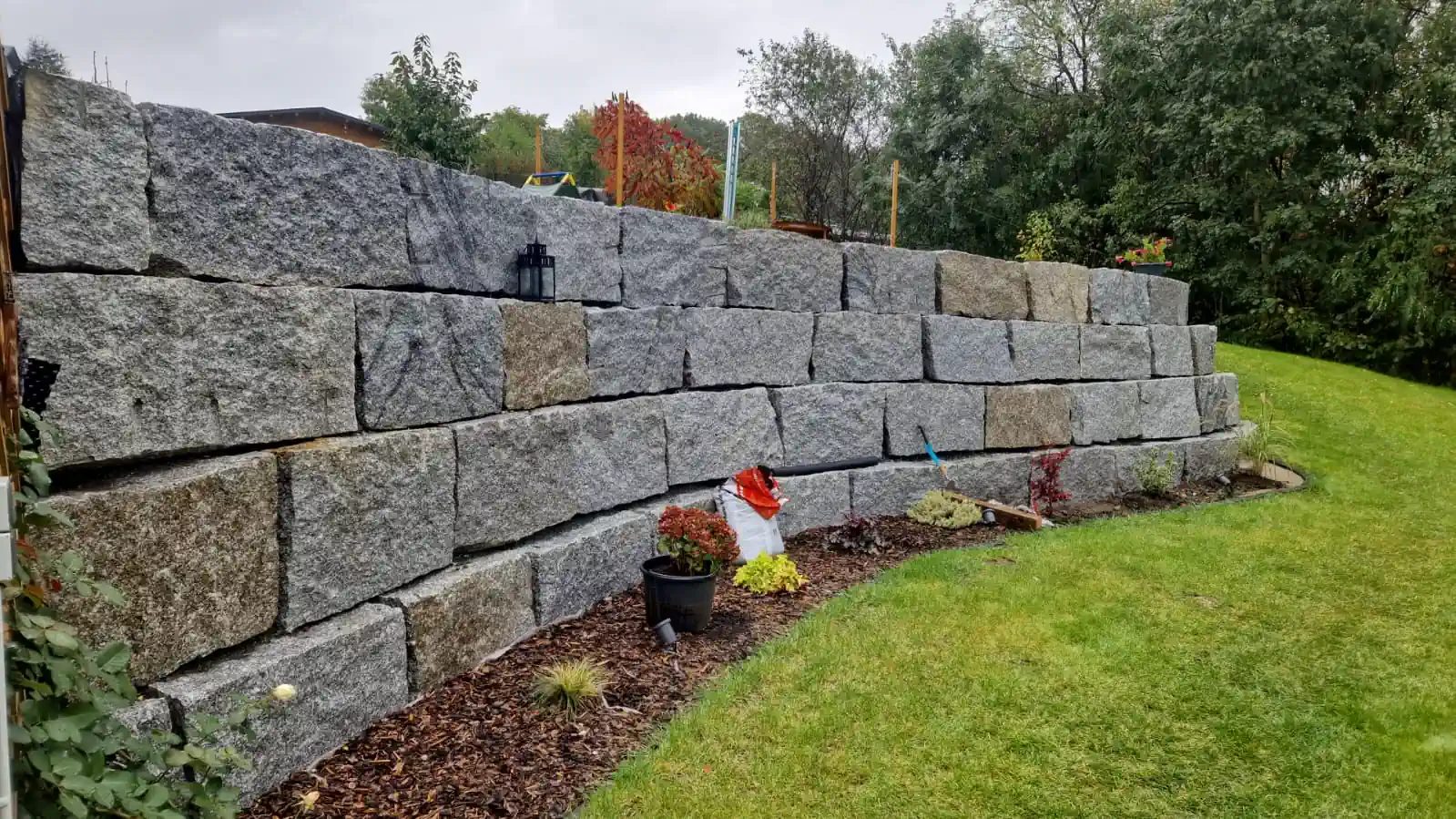 Erdbau mit Baggersteuerung und Granit Großformat Trockenmauer